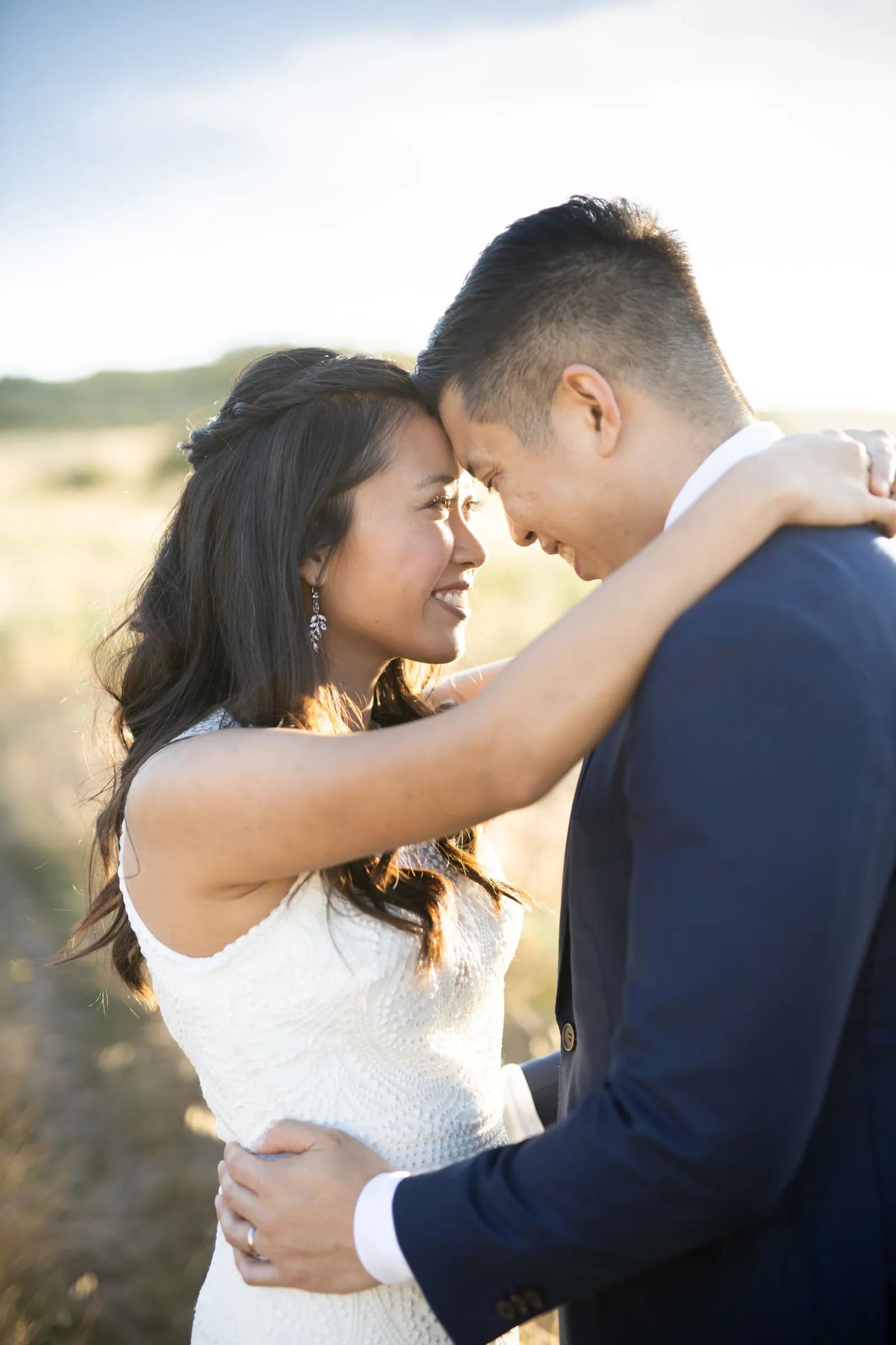 Bride and groom touching foreheads in a warm embrace