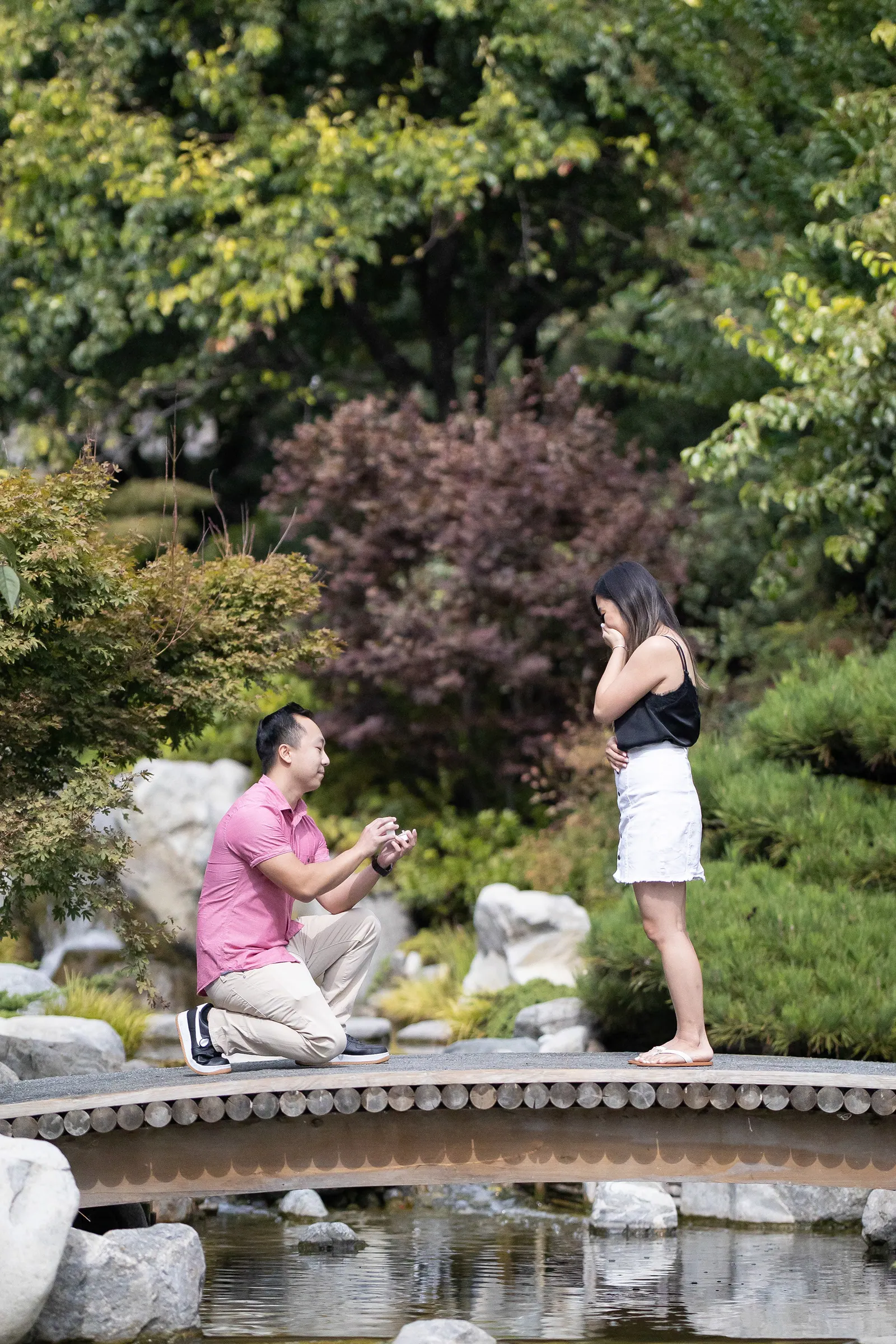Proposal moment: man on one knee in a Japanese garden