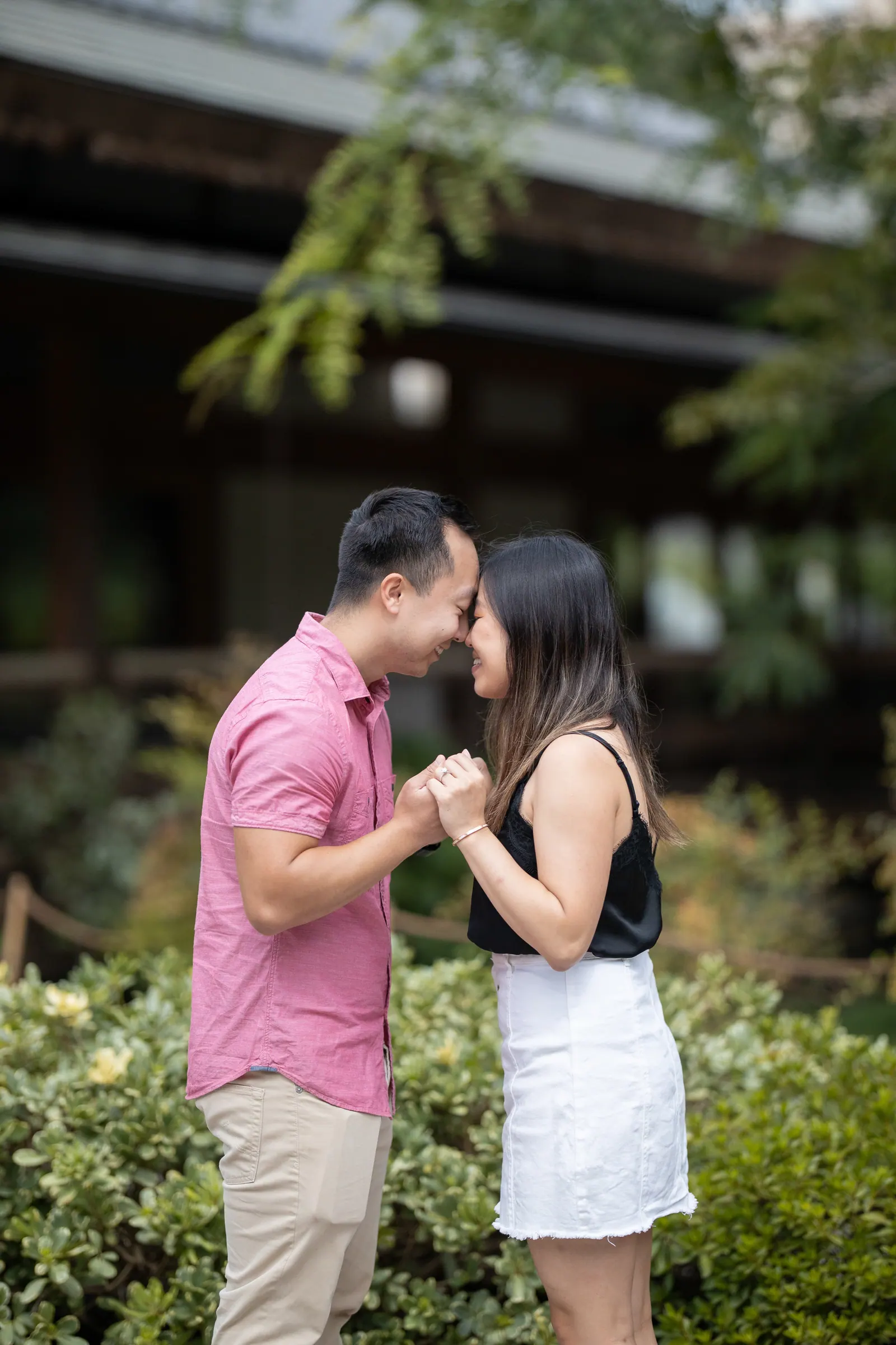 Couple sharing a kiss in a garden after the proposal