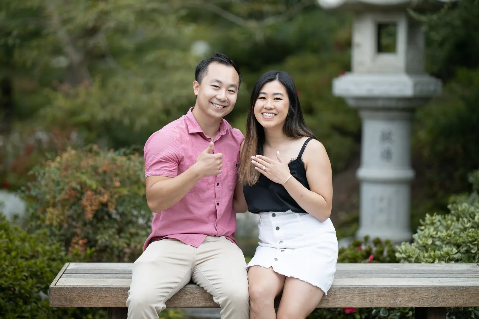 Couple sitting on a stone bench beside a garden lantern