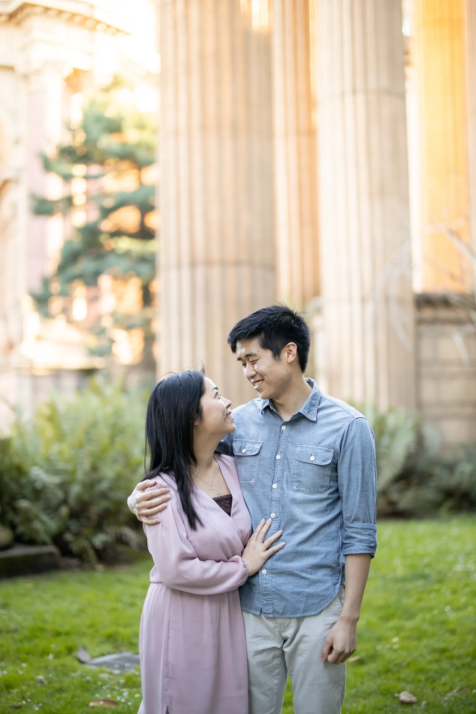 Couple standing close together among garden greenery