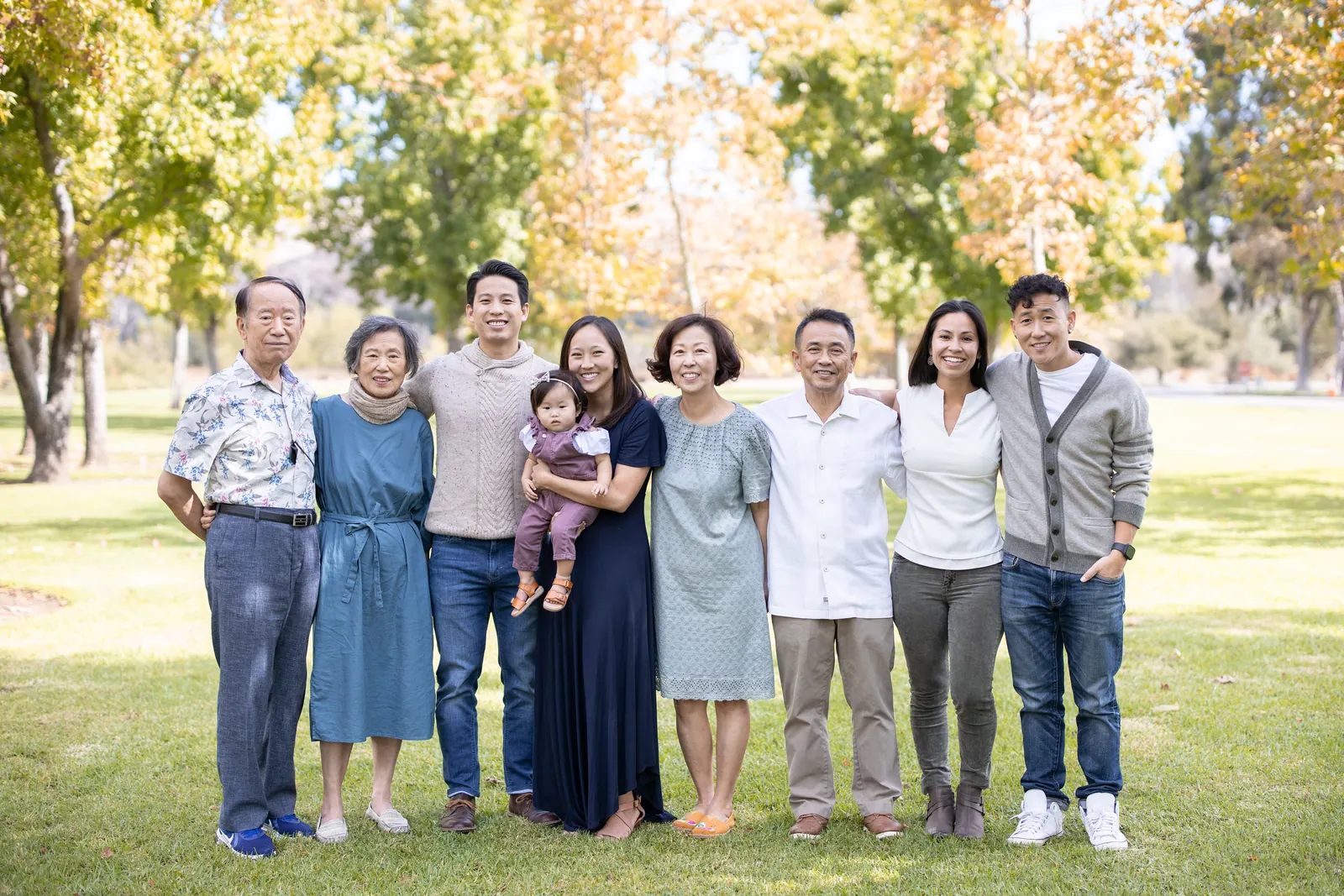 Large extended family standing together in a park