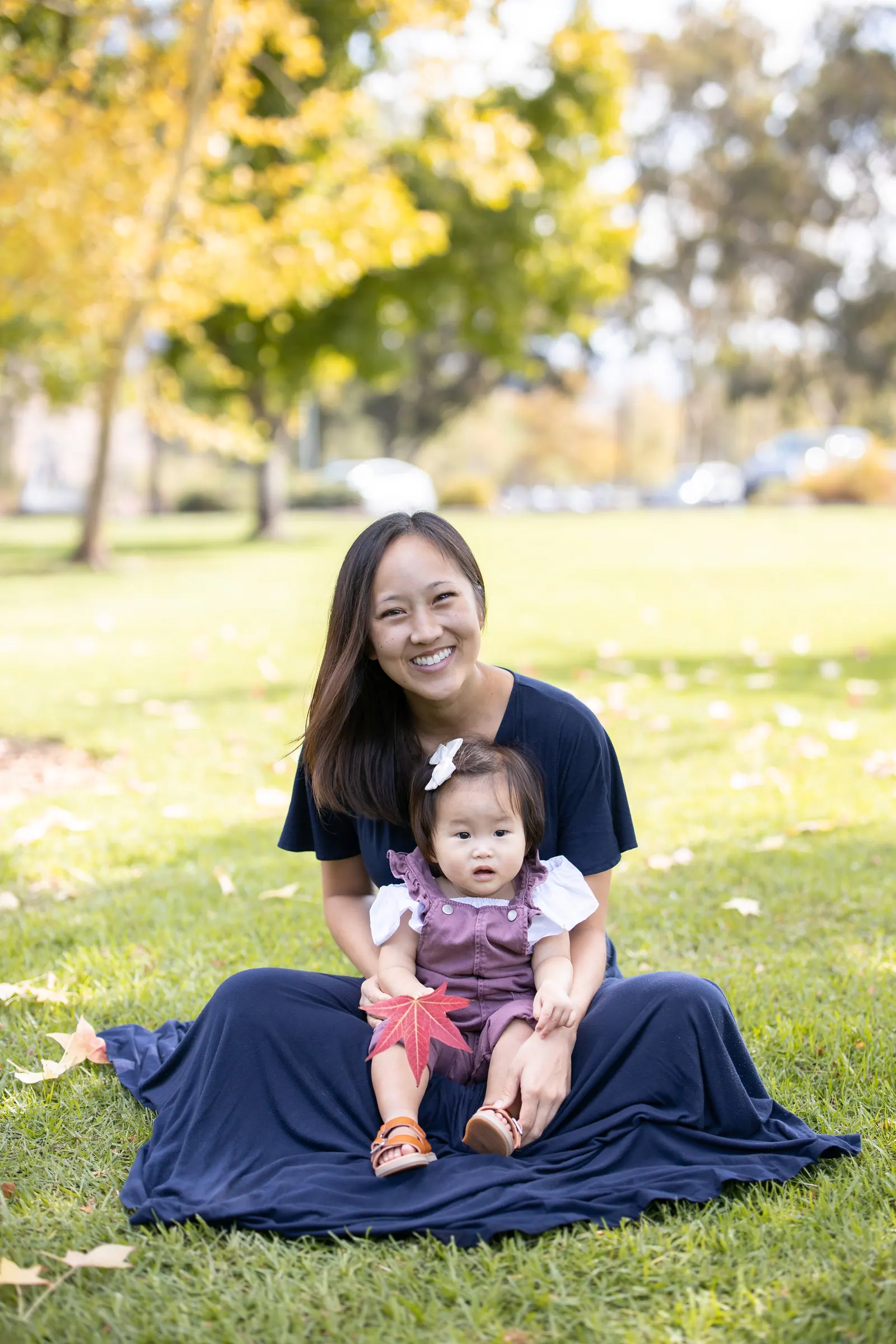 Mother sitting on the grass with her baby daughter