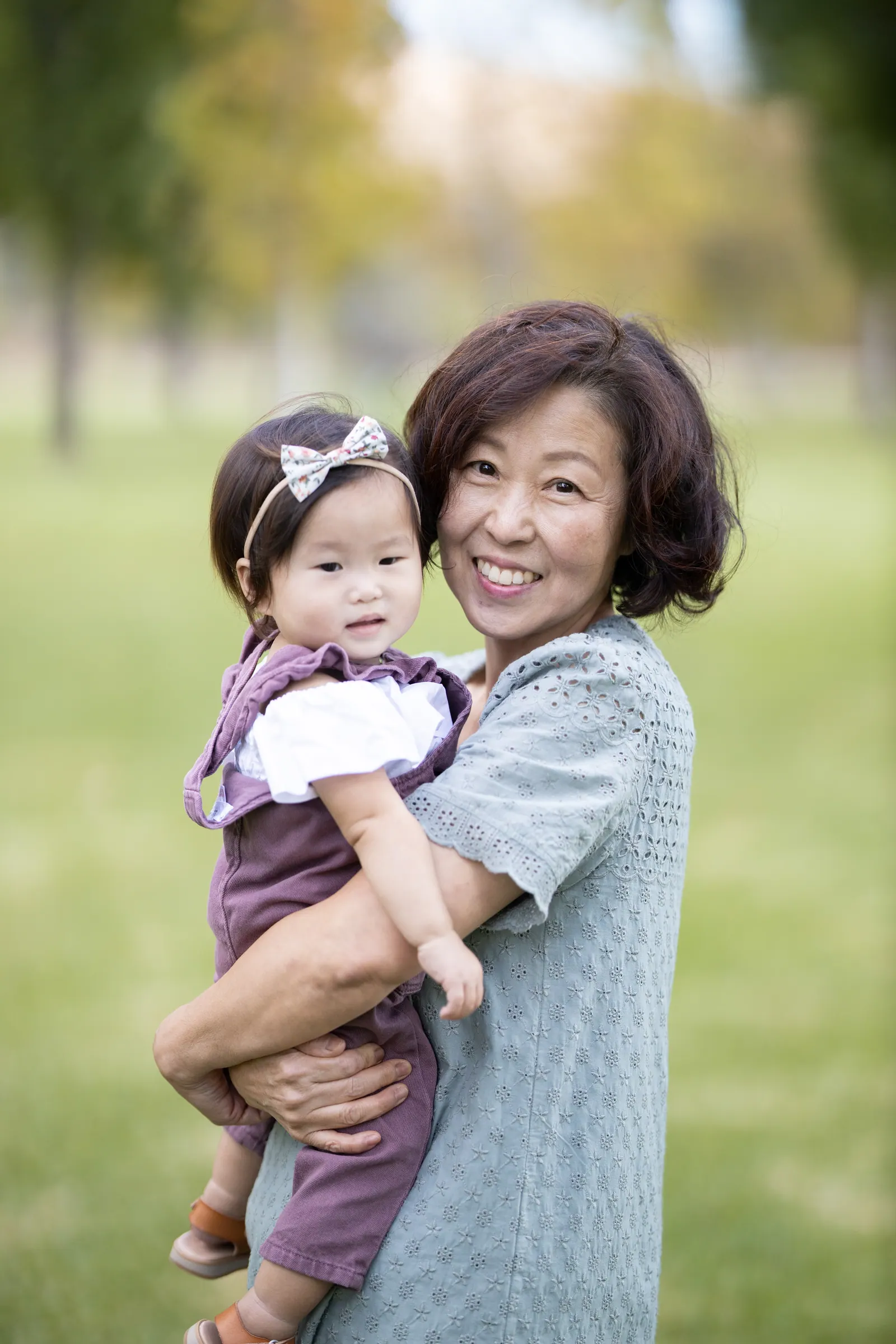 Grandmother holding her granddaughter outdoors