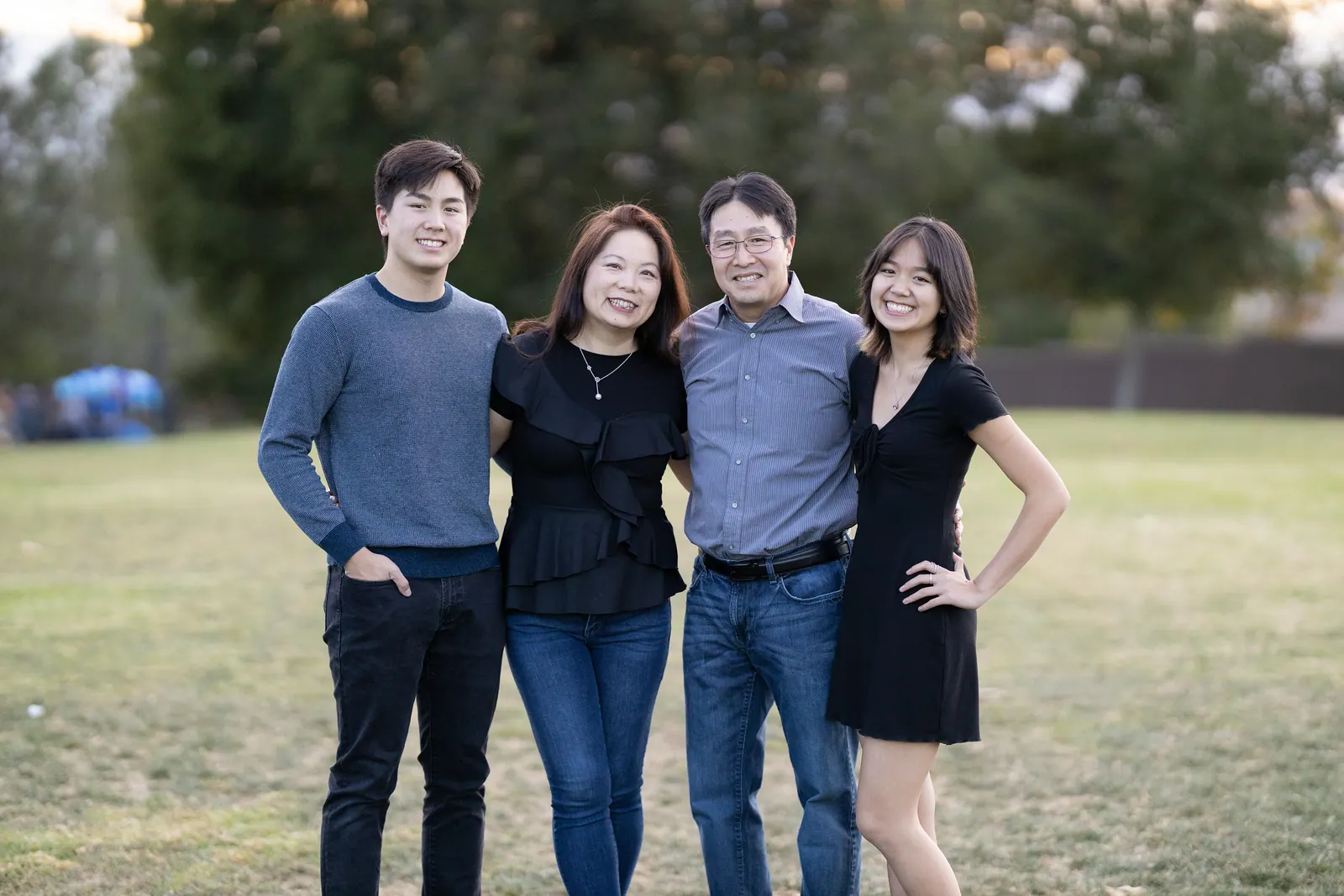 Family of four standing together on a lawn