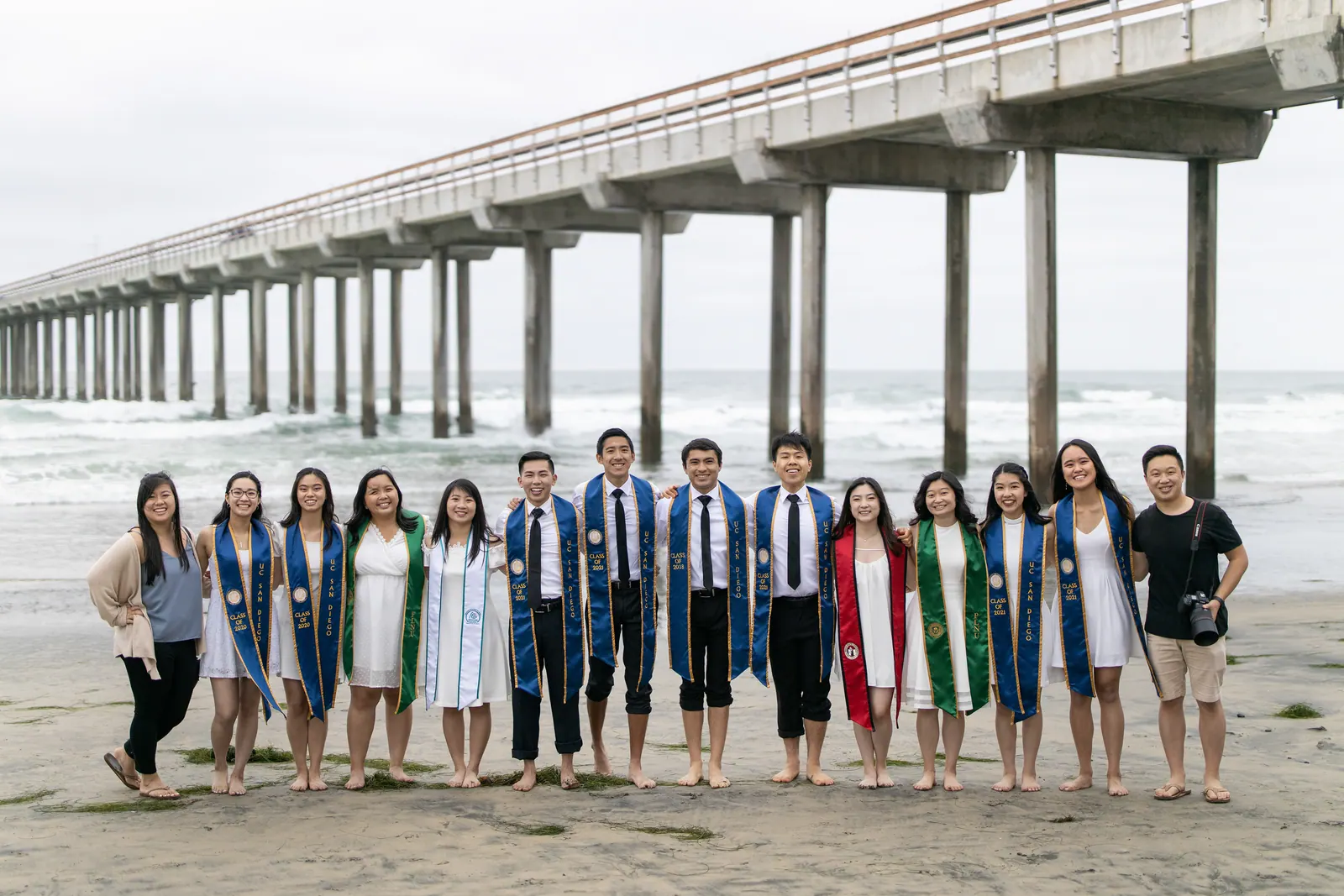 Large group of graduates on the beach beside Scripps Pier