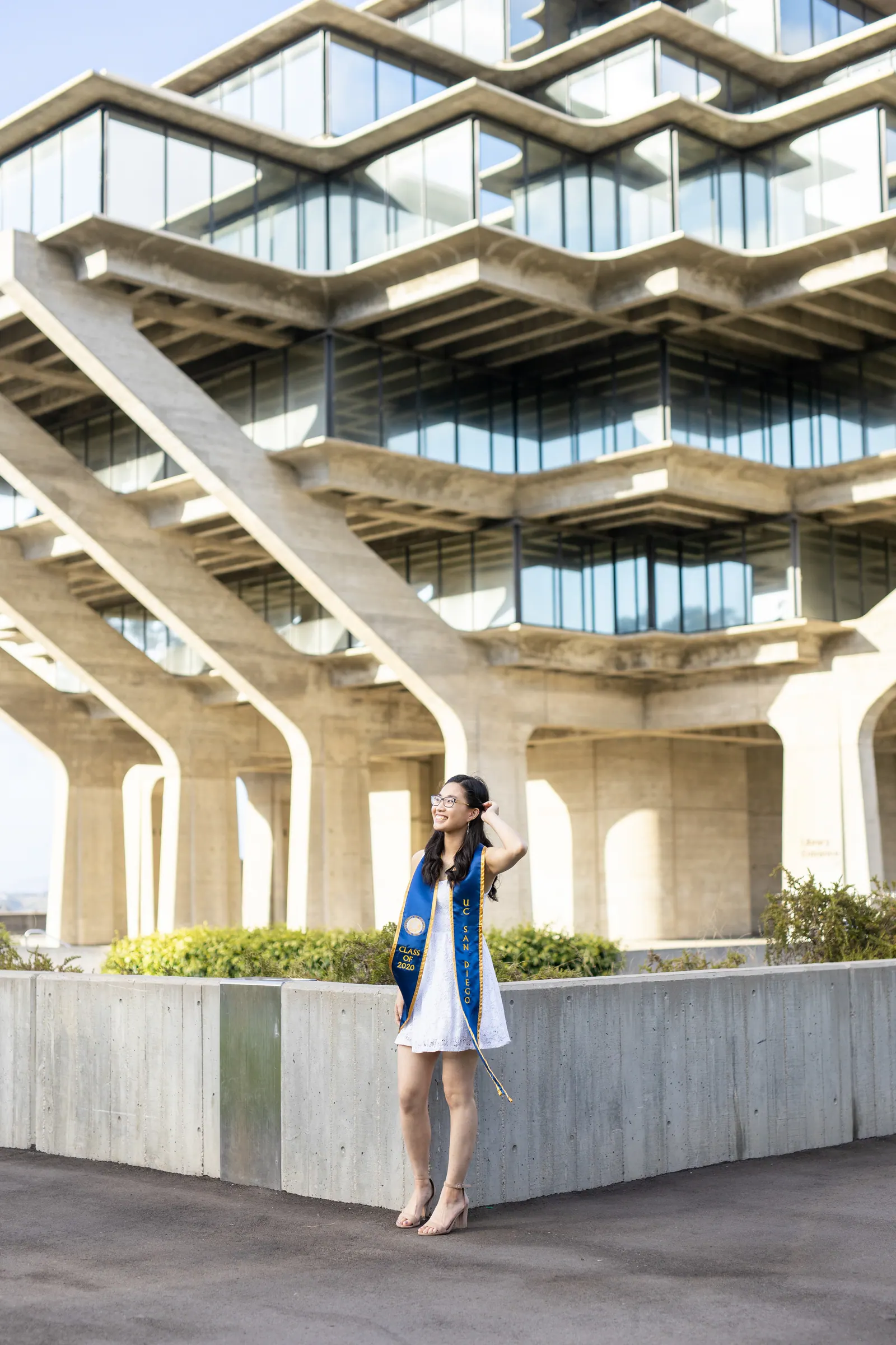 Graduate standing below Geisel Library's tiered concrete structure