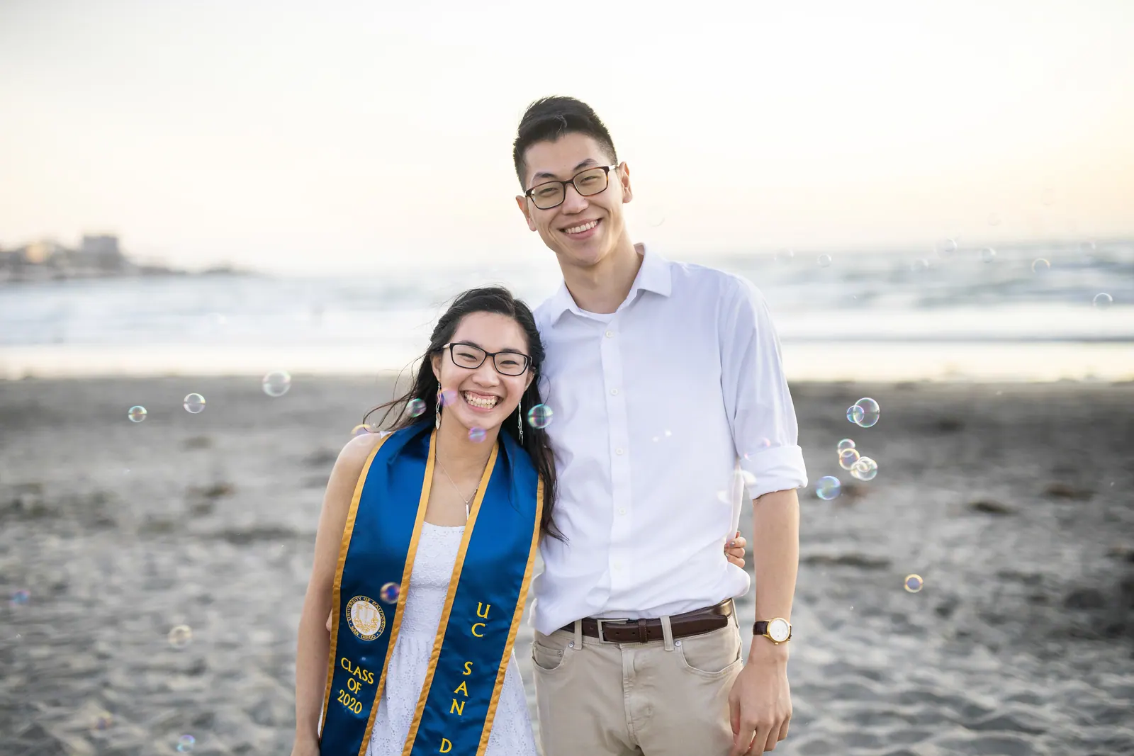 Graduate and friend smiling at the beach