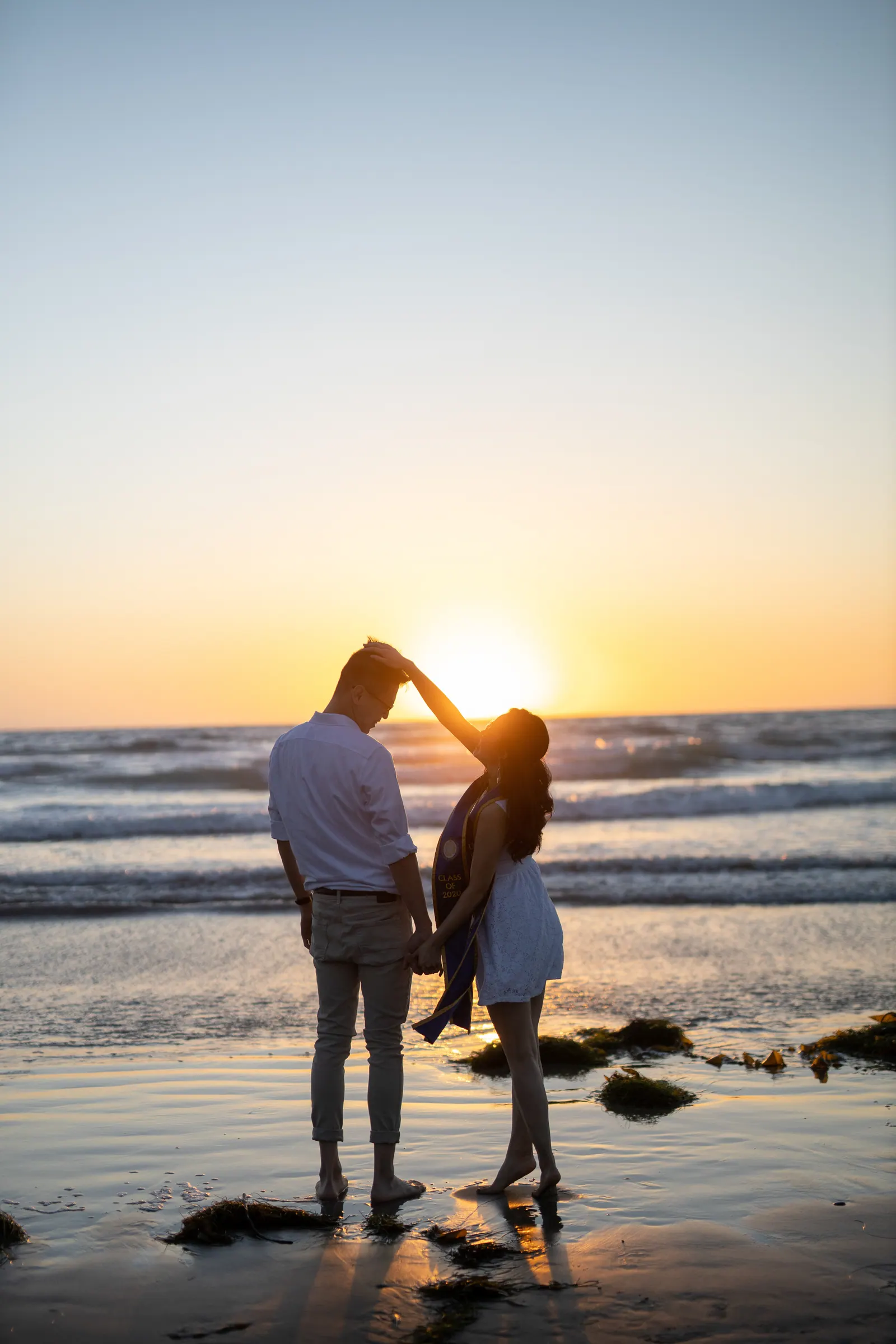 Couple silhouetted at sunset on the beach
