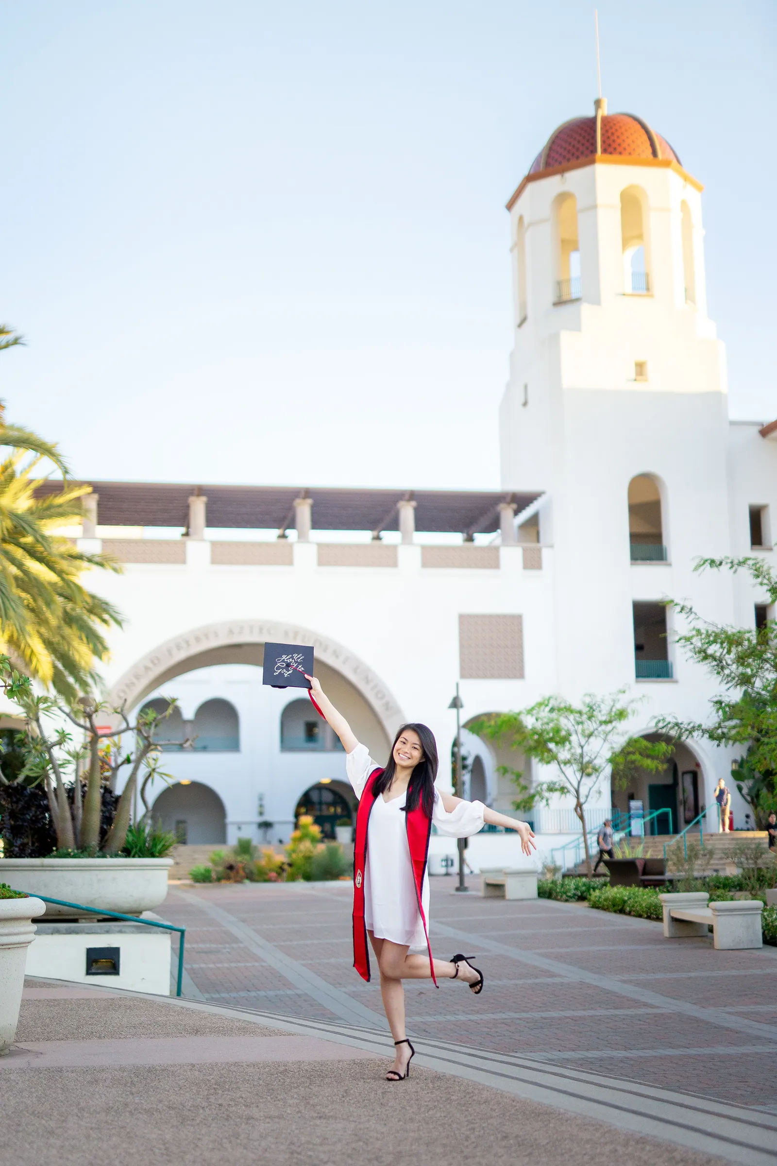 Graduate walking in front of Hepner Hall at San Diego State