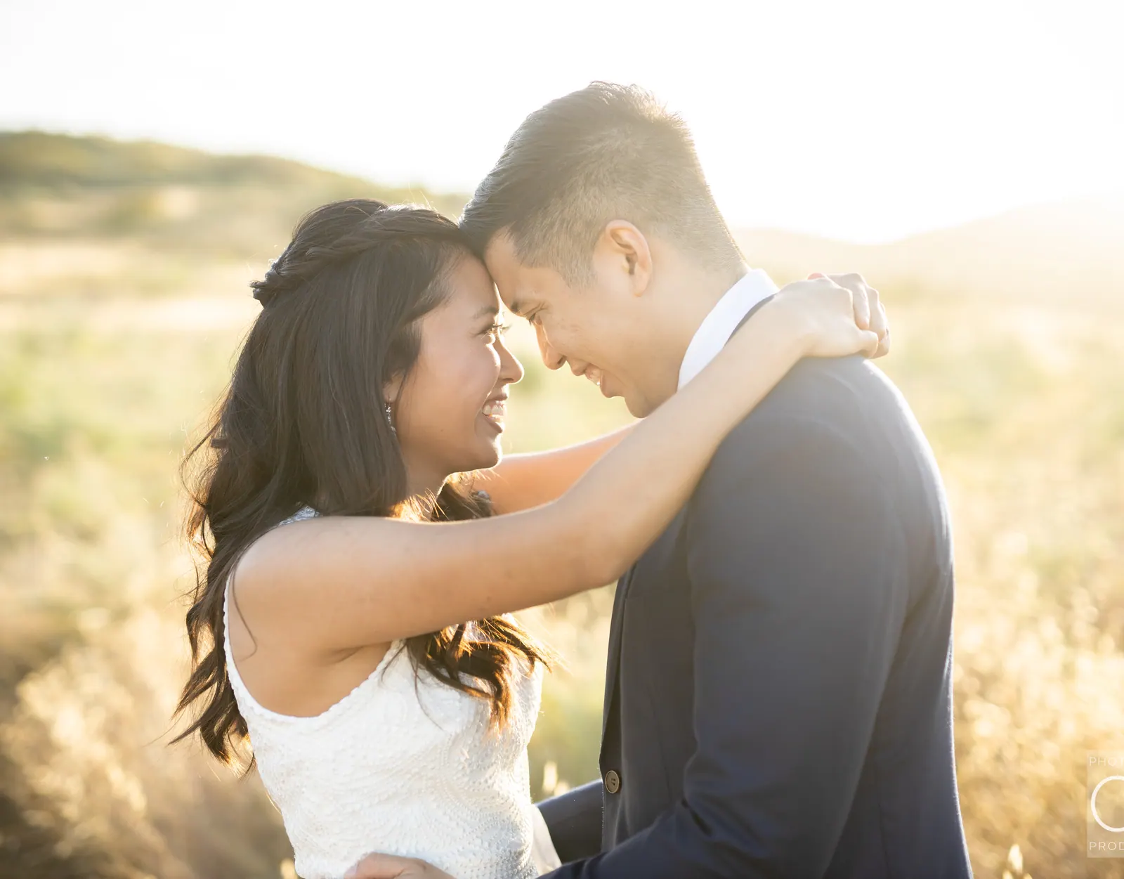 Bride and groom touching foreheads at golden hour