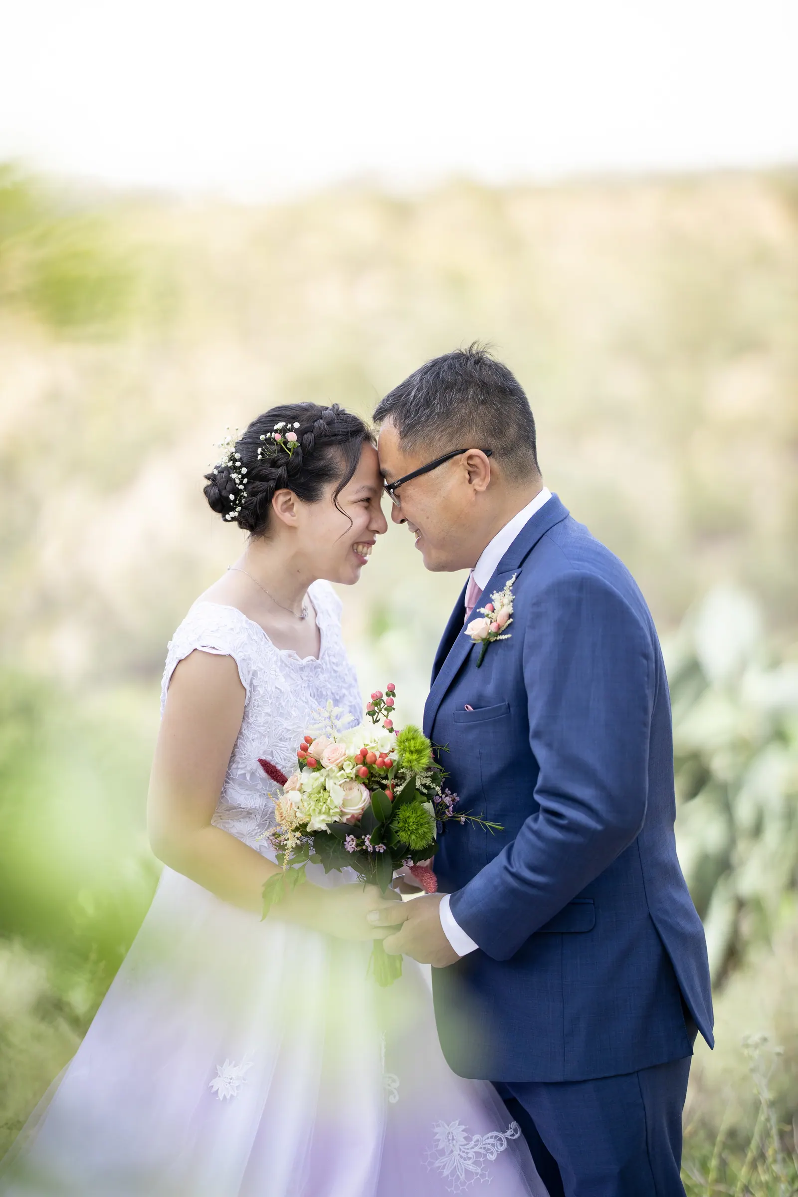 Close portrait of the bride and groom touching foreheads