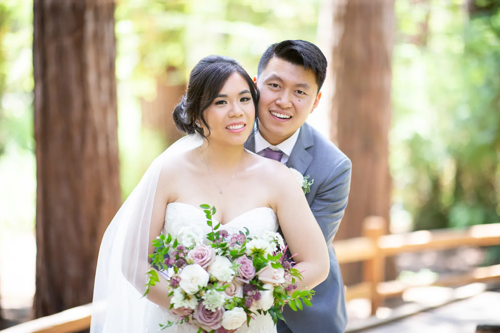 Bride and groom smiling close together with her bouquet
