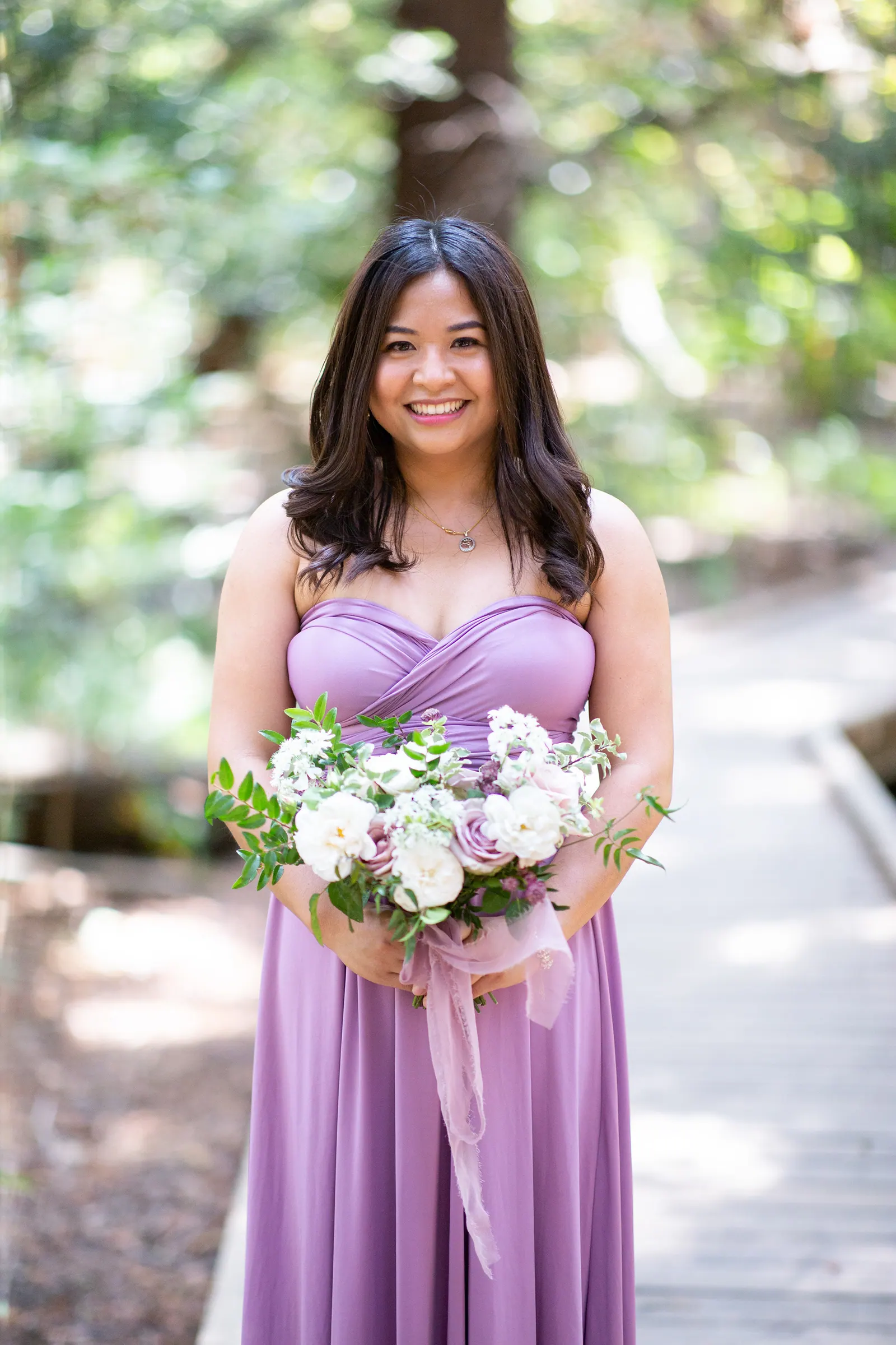 Bridesmaid in a lavender dress holding a bouquet