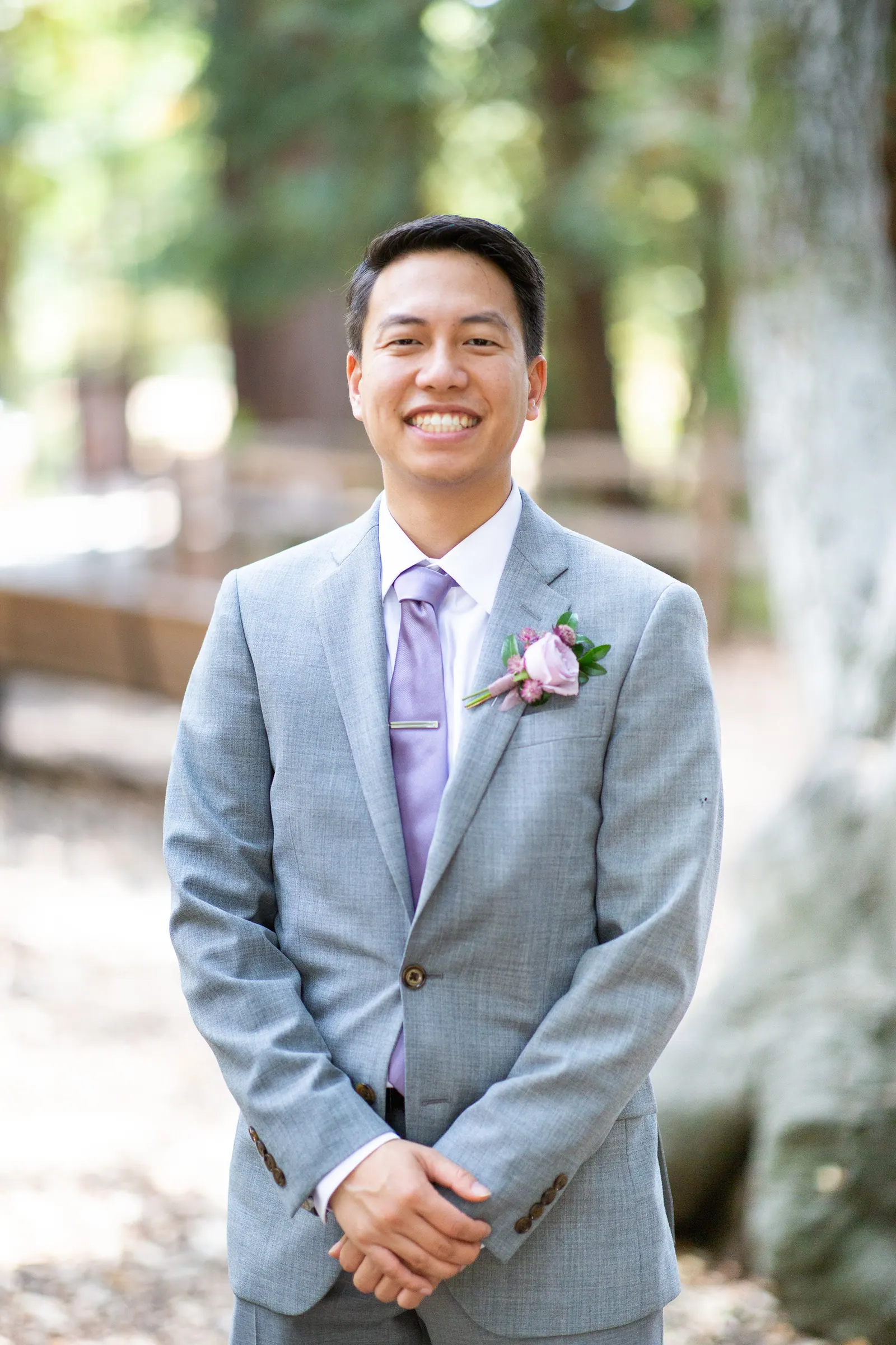 Groomsman in a grey suit with a lavender tie