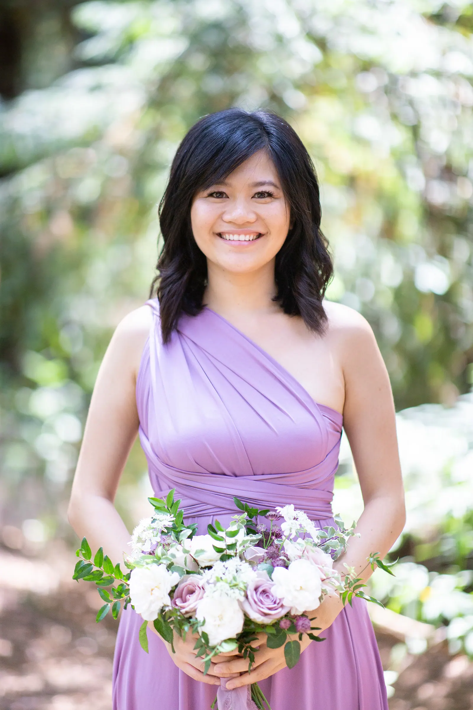 Bridesmaid in lavender holding a bouquet among redwoods