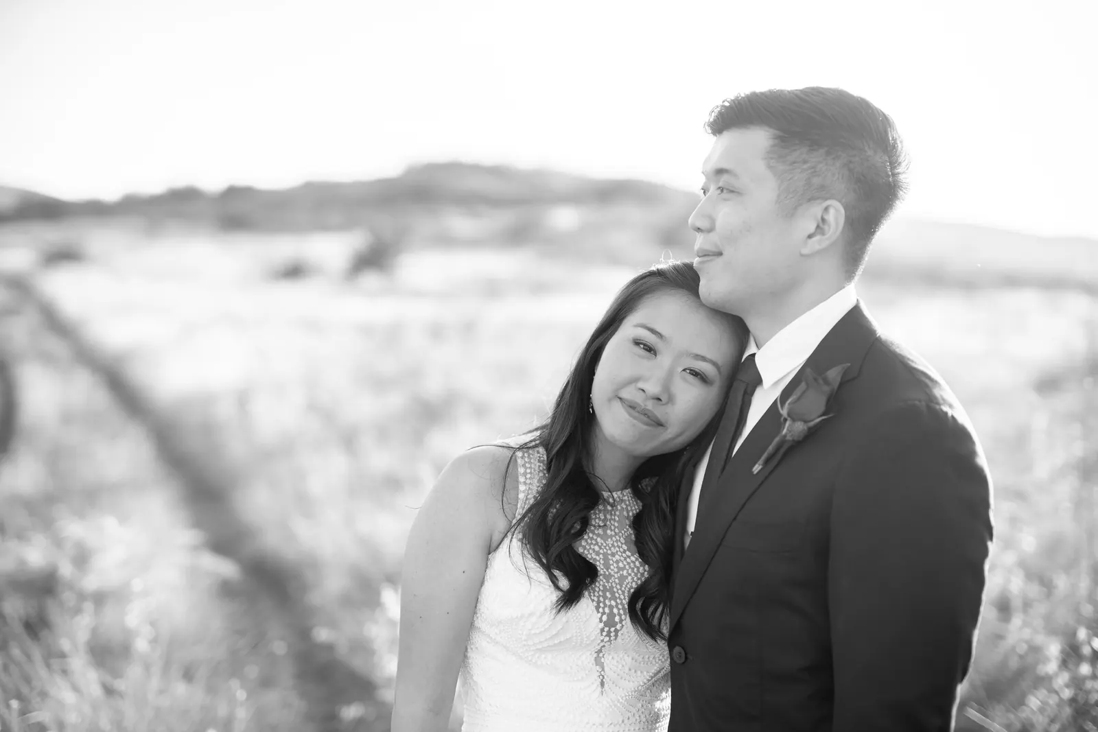 Black and white portrait of the bride leaning on the groom's shoulder
